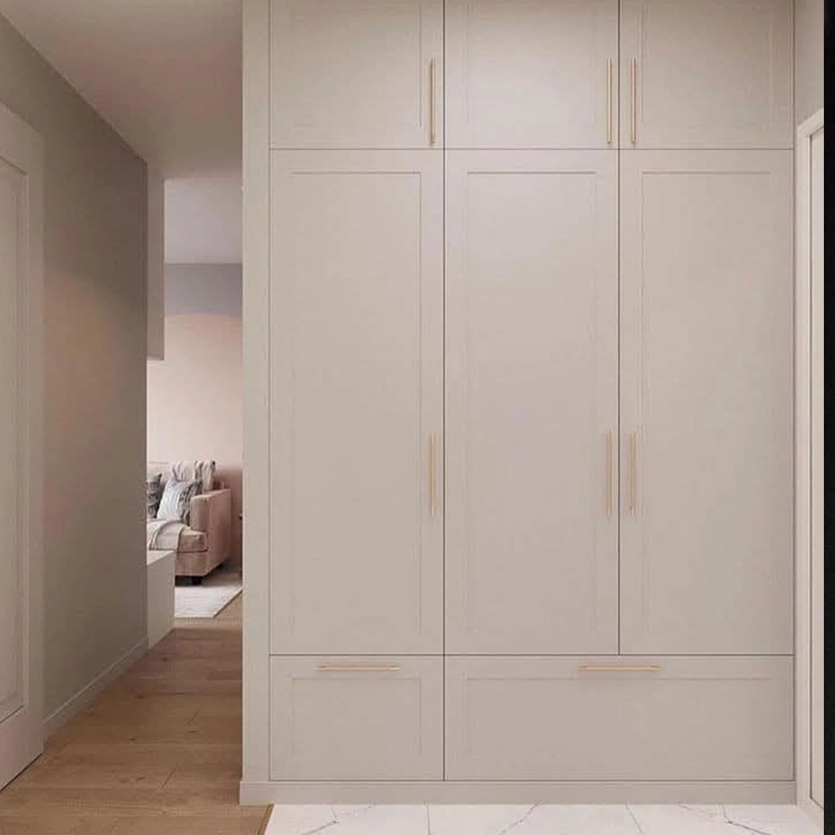 Deckenhoher Einbauschrank im Flur mit Rahmenfronten in warmem Greige und schmalen goldenen Griffleisten: Aufsatzschränke oben, hohe Türen in der Mitte, Schubladen im Sockelbereich.